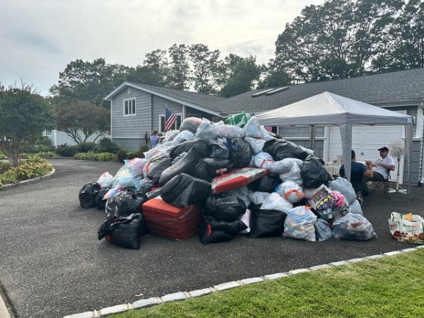 Supporters posing with full donation bags for a local team fundraiser